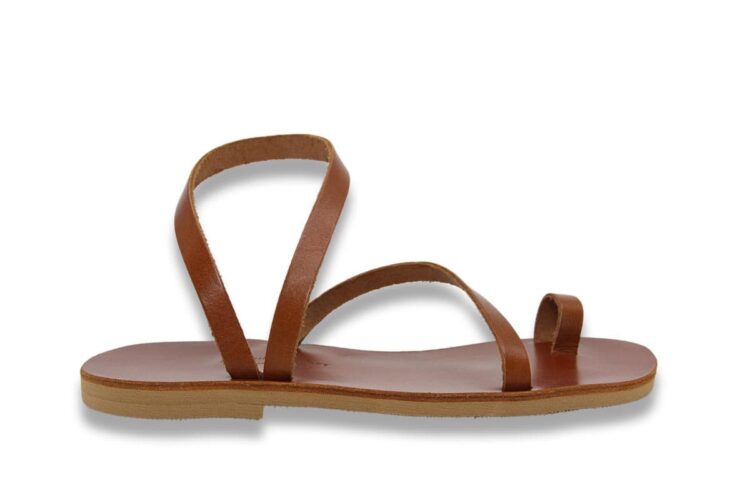 A brown leather sandal with a flat sole, toe strap, and two crossing ankle straps, shown in a side profile on a white background.