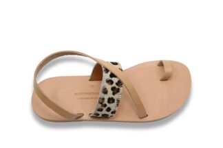 Sandale en cuir naturel vachetta beige avec une bride sur le coup de pied à imprimé léopard, une boucle d'orteil et une bride diagonal sur le coup de pied et qui passe derrière la cheville, affichée sur un fond blanc. Vue supérieure. Modèle Patmos Leo.